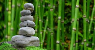 image of s stack of gray stones ina green bamboo garden for stress relief