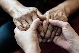 two sets of hands holding representing hospice nurses