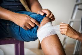 a wound, ostomy and continence WOC nurse bandaging a patient's leg