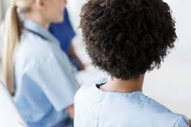 the backs of heads of two nurses, one Black, one white to depict racism in nursing